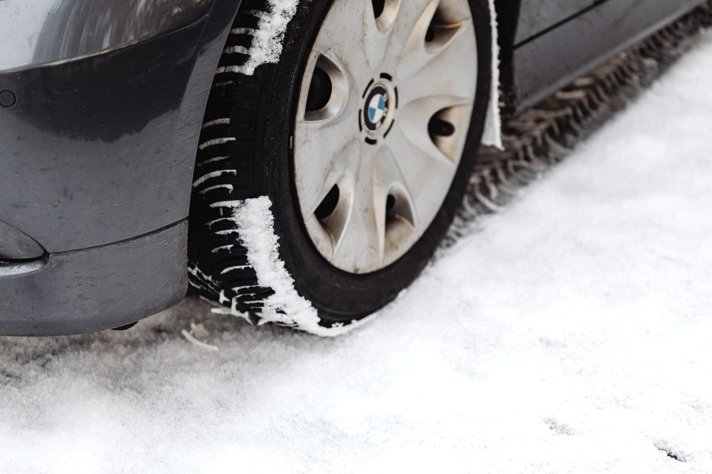 A car tire on a snow-covered road surface