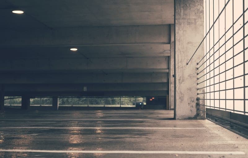 A garage floor with meltwater and salt residue under a parked car - a stand-in for the Drymate Garage Floor Containment Mat, not a photograph of this model