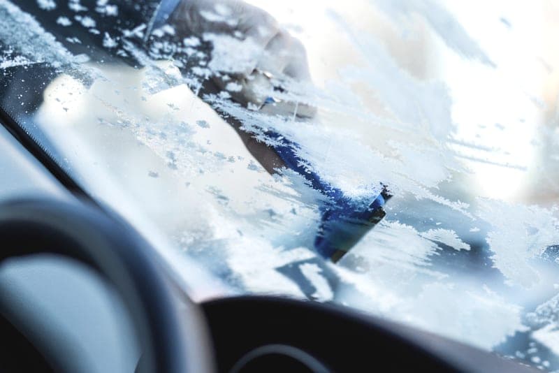 Ice being cleared from a car windshield - a stand-in for the Prestone Windshield De-Icer, not a photograph of this model